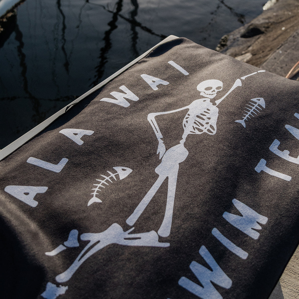 Black shirt with skeleton and fish bone graphic, quick-dry fabric, swim team theme.