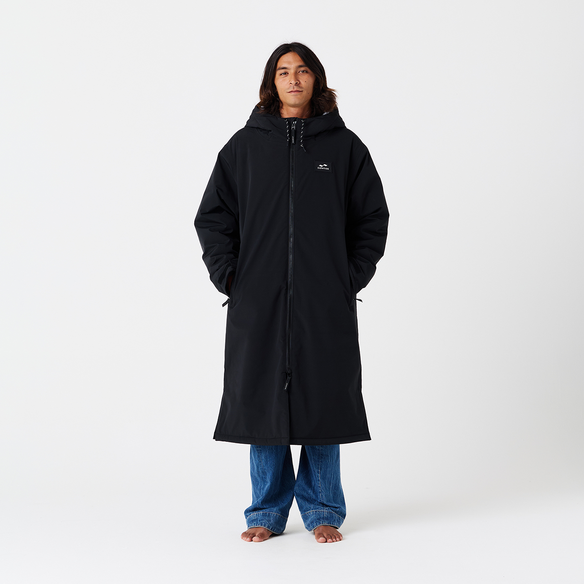 Black insulated parka with blue jeans, shown for fit and style.