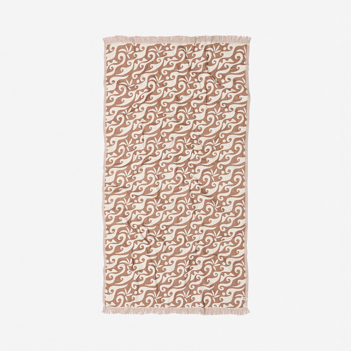 Beige cotton towel with white wave print and fringe on short edges.