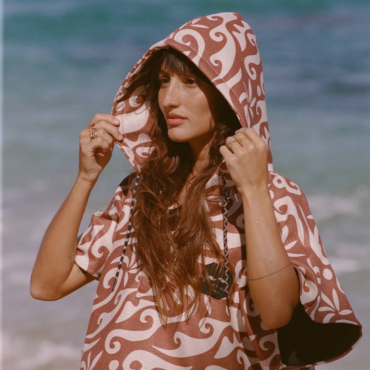 Patterned recycled-material changing poncho with hood.