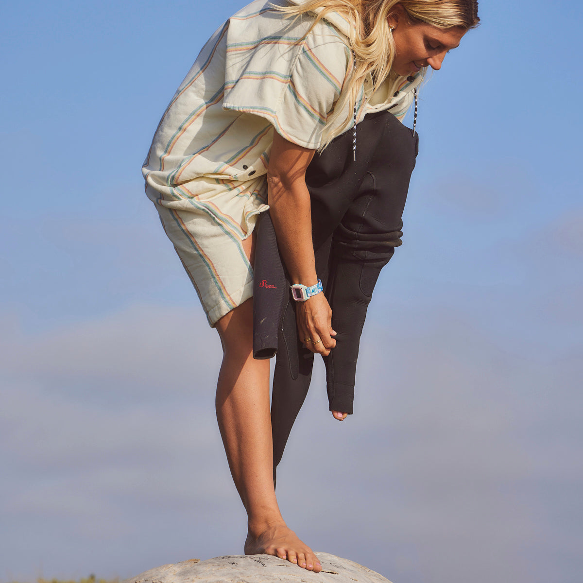 Wetsuit in lightweight, quick-dry fabric over striped shirt, outdoor setting.