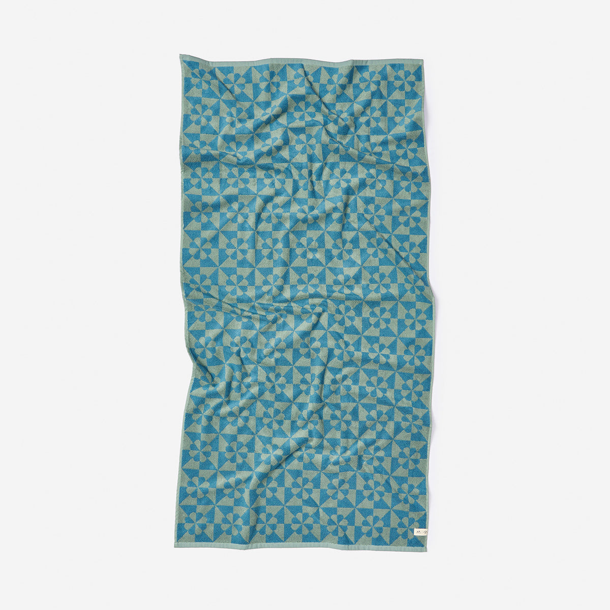 Bathroom towel with dusty blue star-like geometric pattern, shown flat.