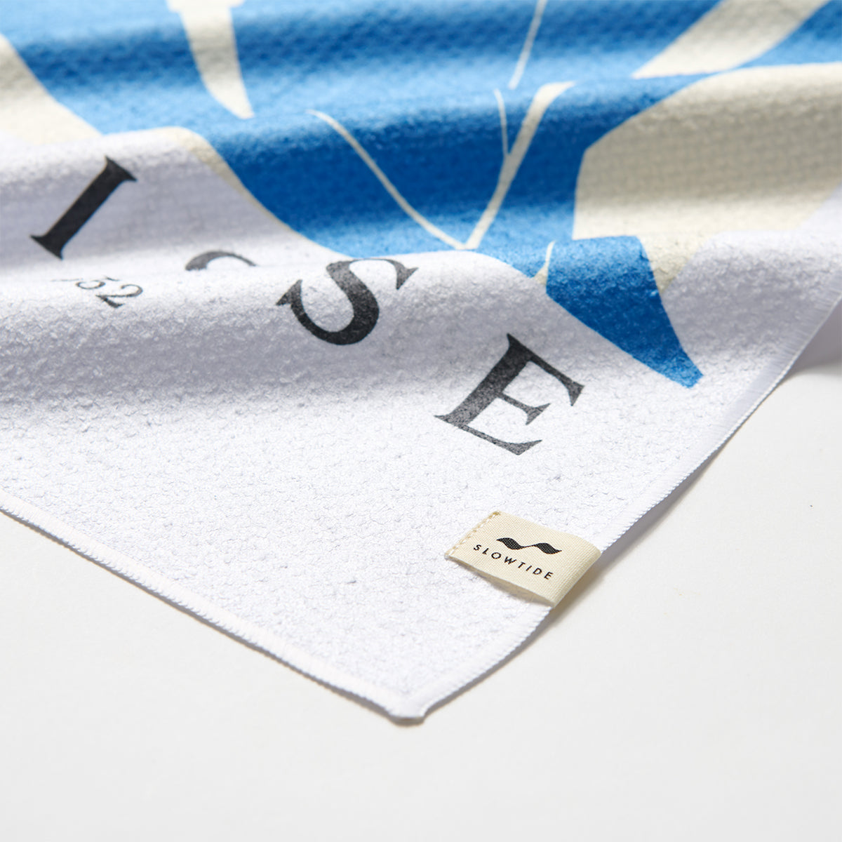 Kitchen towel, cotton, white and blue stripes, close-up of corner detail.