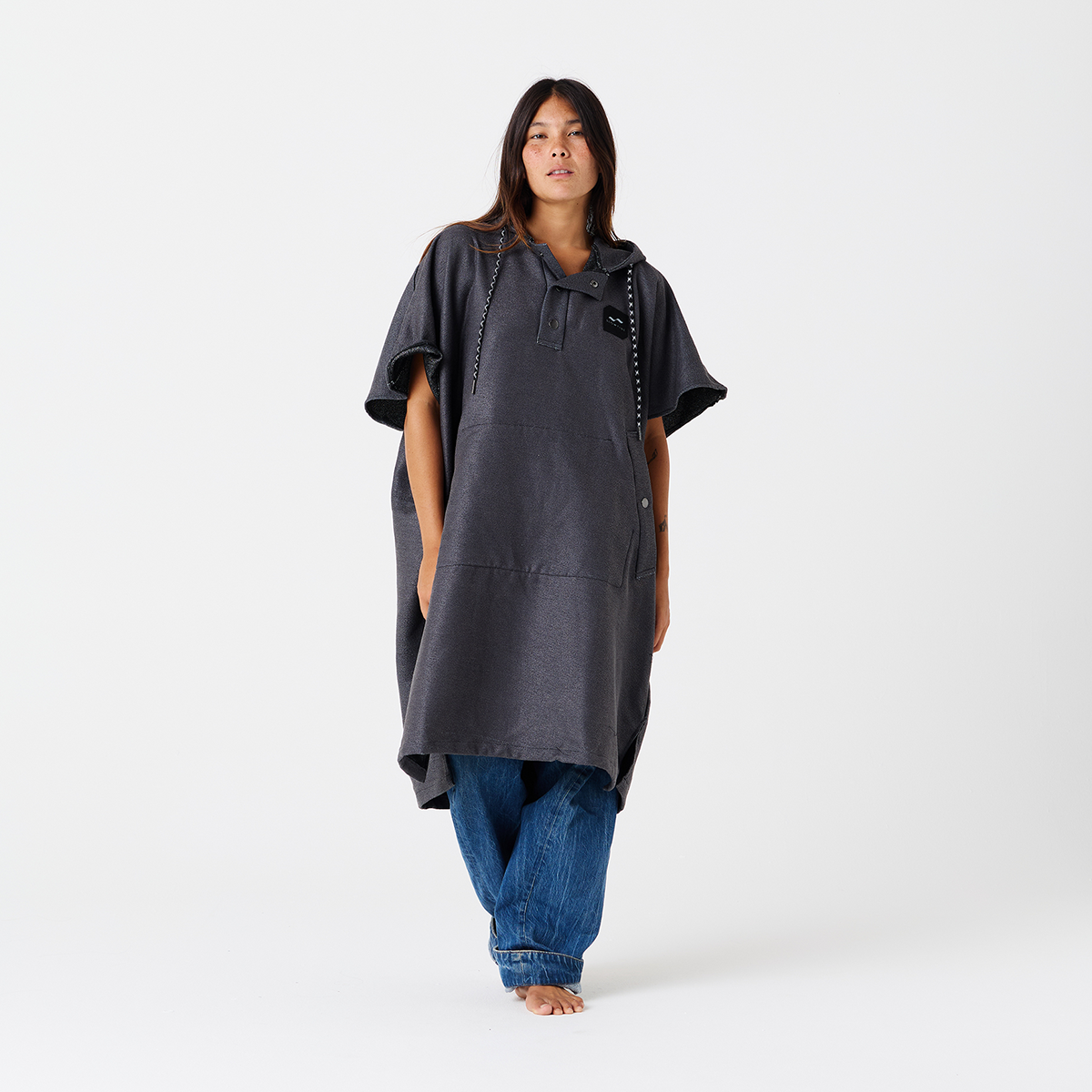 Dark gray changing poncho, quick-drying recycled material, shown over blue jeans.