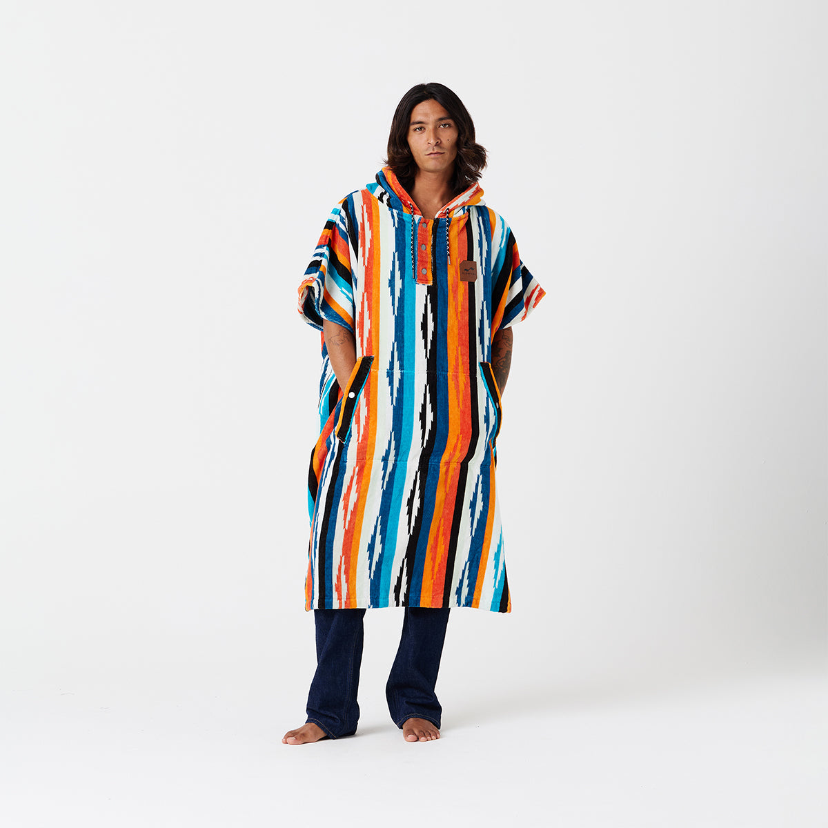 Cotton terry towel poncho with colorful stripes and hood, displayed on white background.