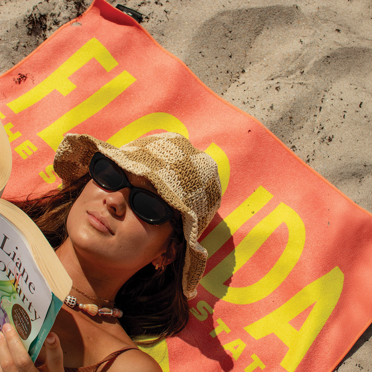 Quick-drying beach towel with FLORIDA text, shown at the beach.