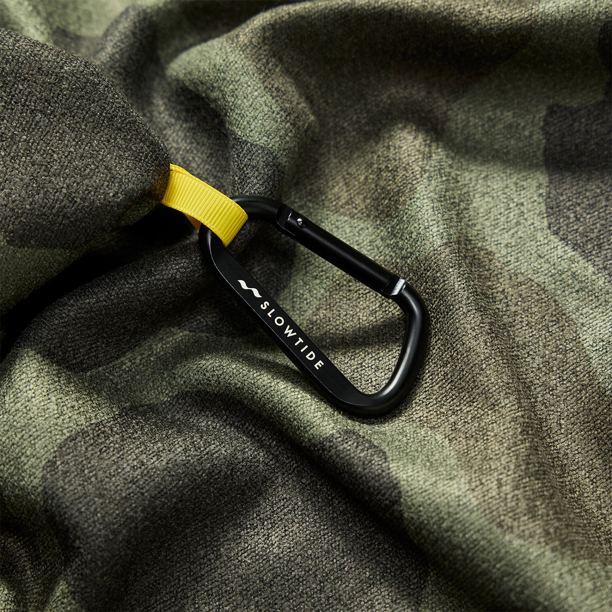 Carabiner on camo towel with yellow strap.