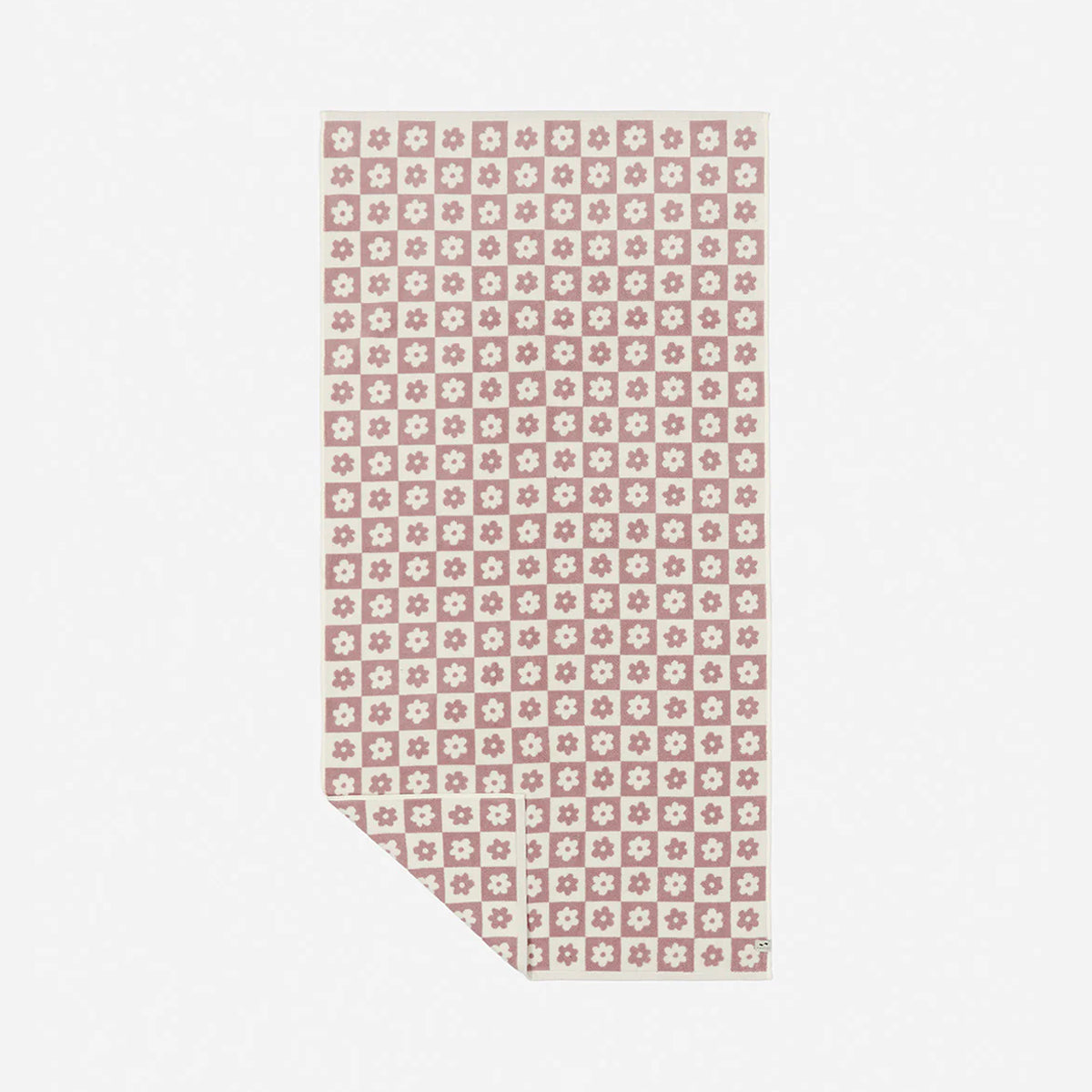 Oversized beach towel with pink and white floral geometric pattern on white background.
