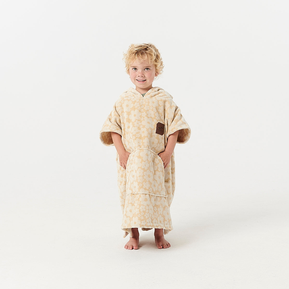 Kids poncho, beige with floral pattern.