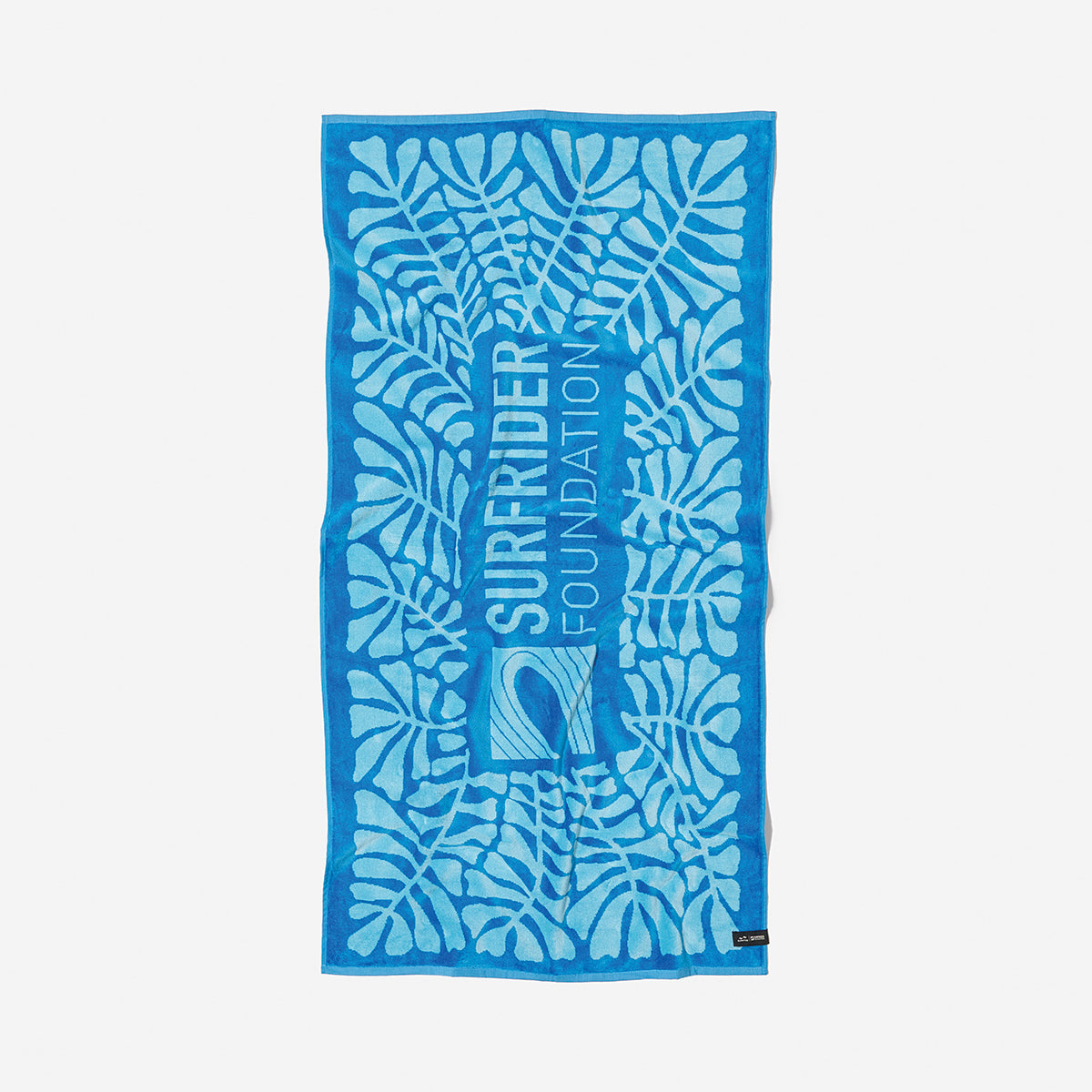 Blue cotton beach towel with leaf pattern and text, made from sustainable materials.
