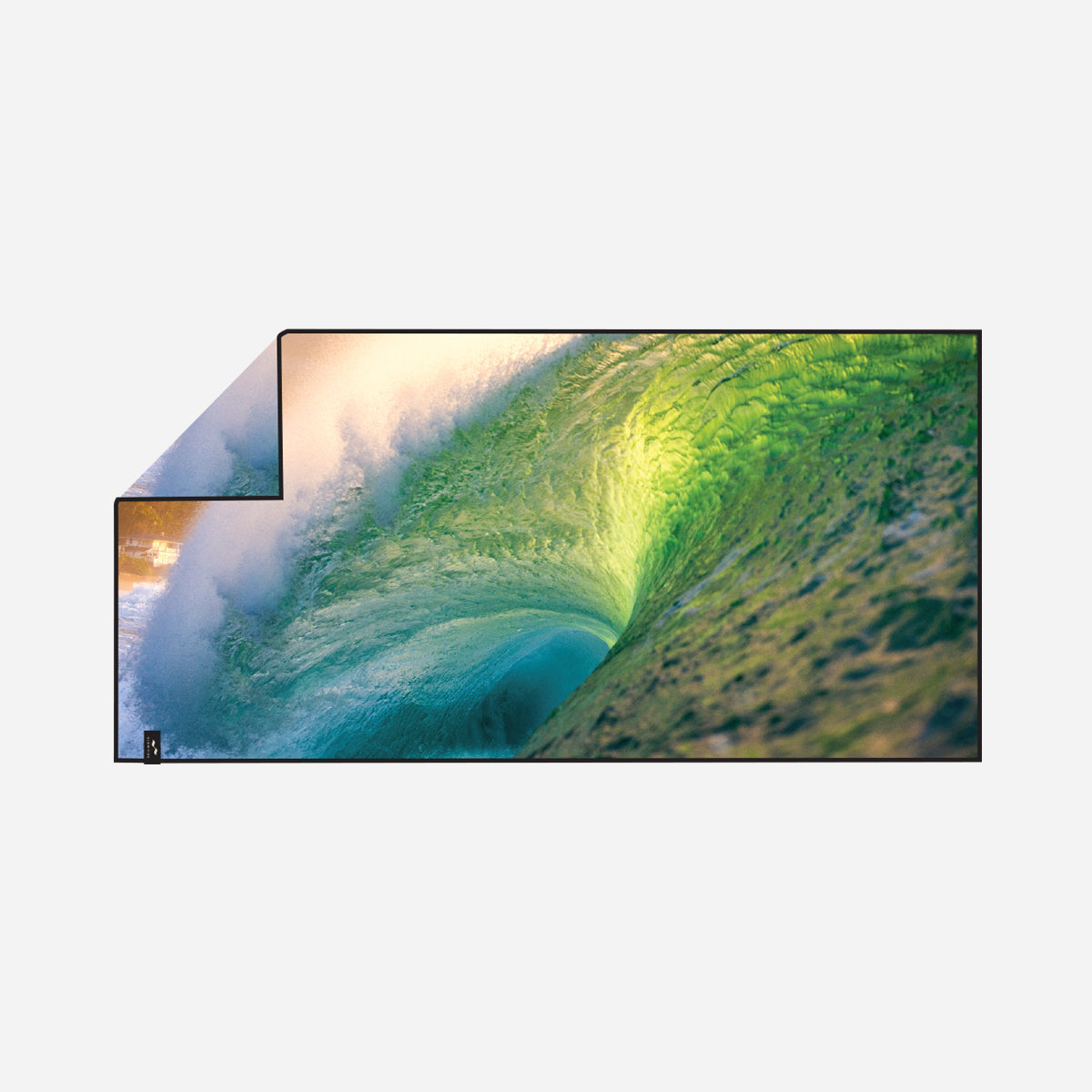 Sand-resistant towel with green ocean wave pattern, shown in natural sunlight.
