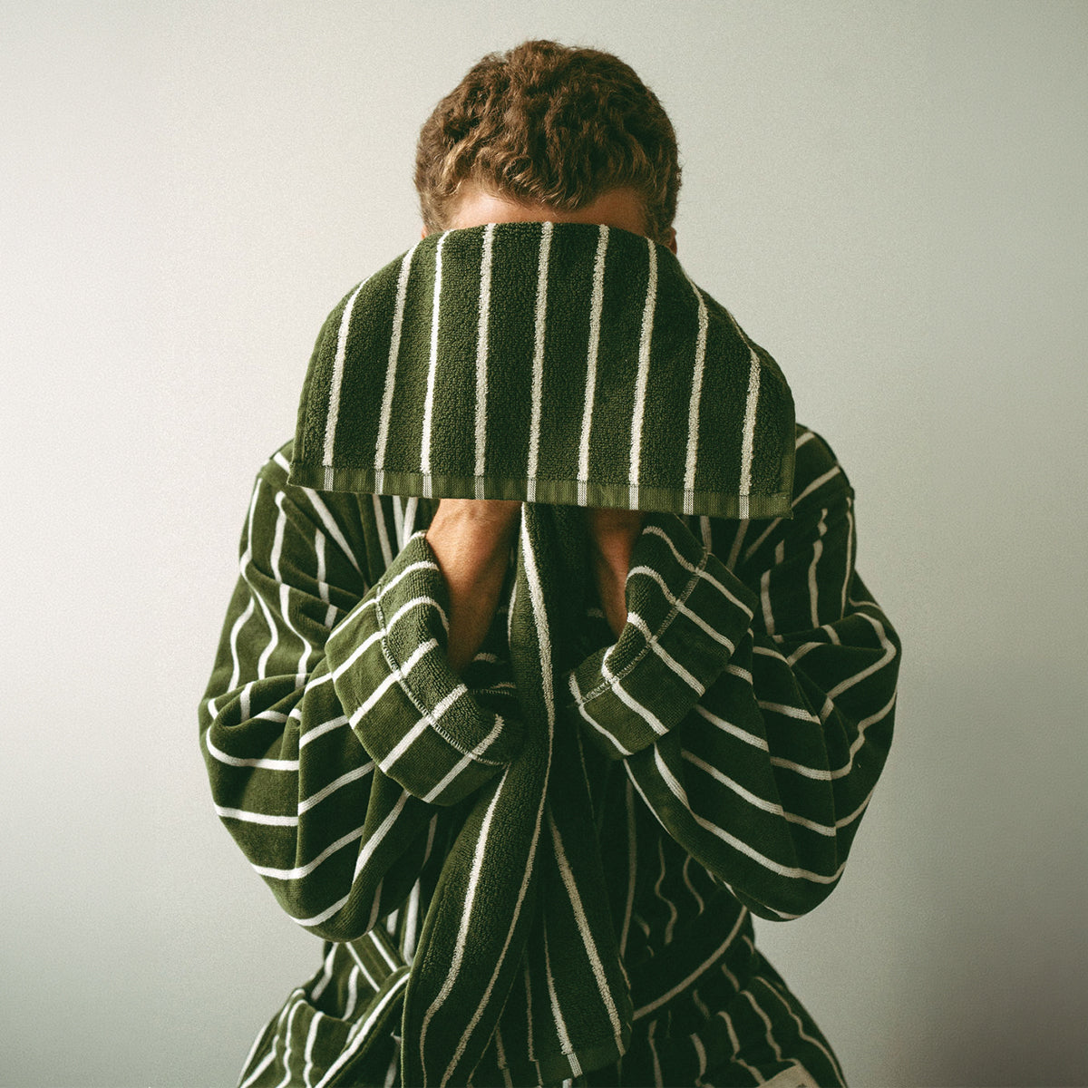 Cotton bathrobe and plush hand towel in green and white stripes.