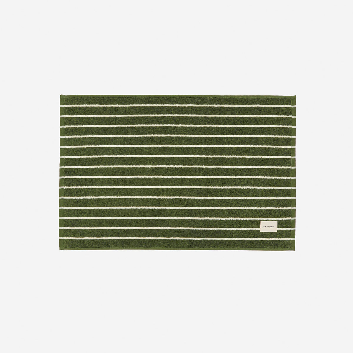 Cotton bath mat with white stripes and small label, absorbent for bathroom use.