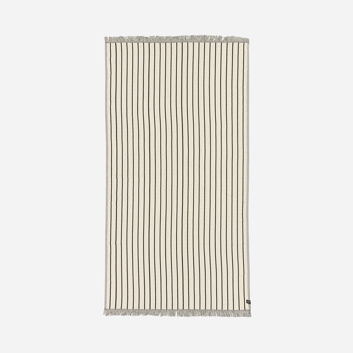 Turkish towel, lightweight beige cotton with thin black stripes and fringe on short ends.