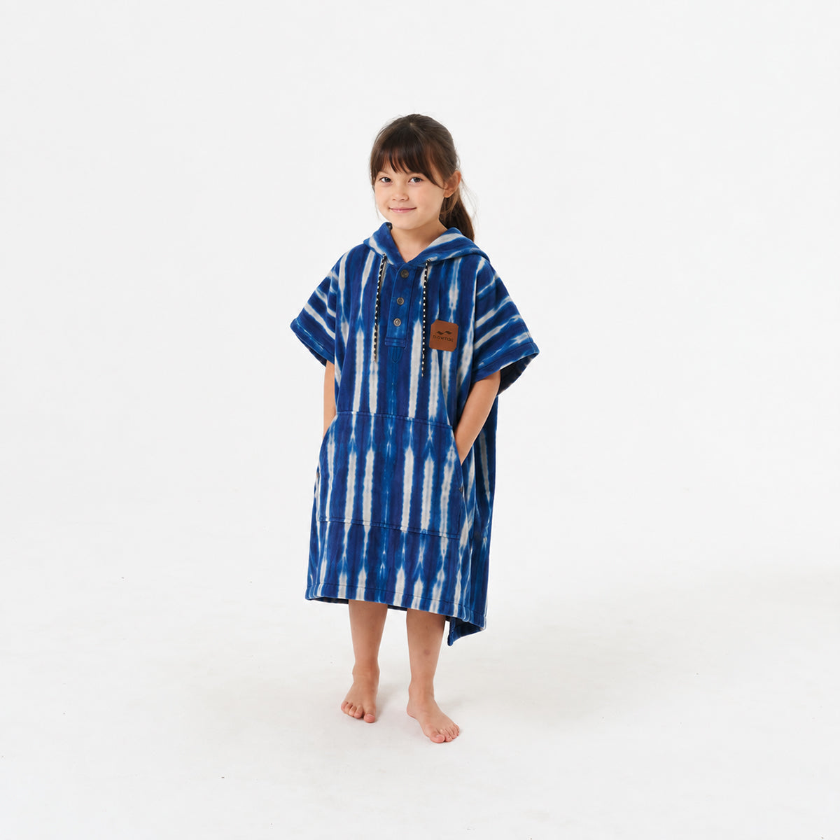 Changing poncho in absorbent cotton with blue and white tie-dye stripes.
