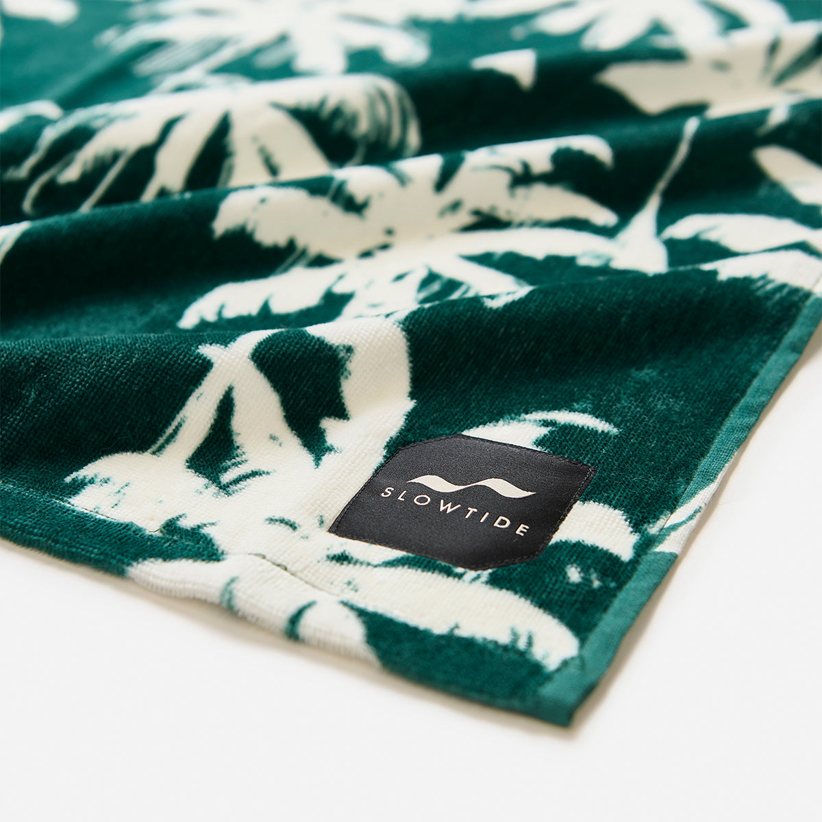 Cotton beach towel with white palm leaf print.