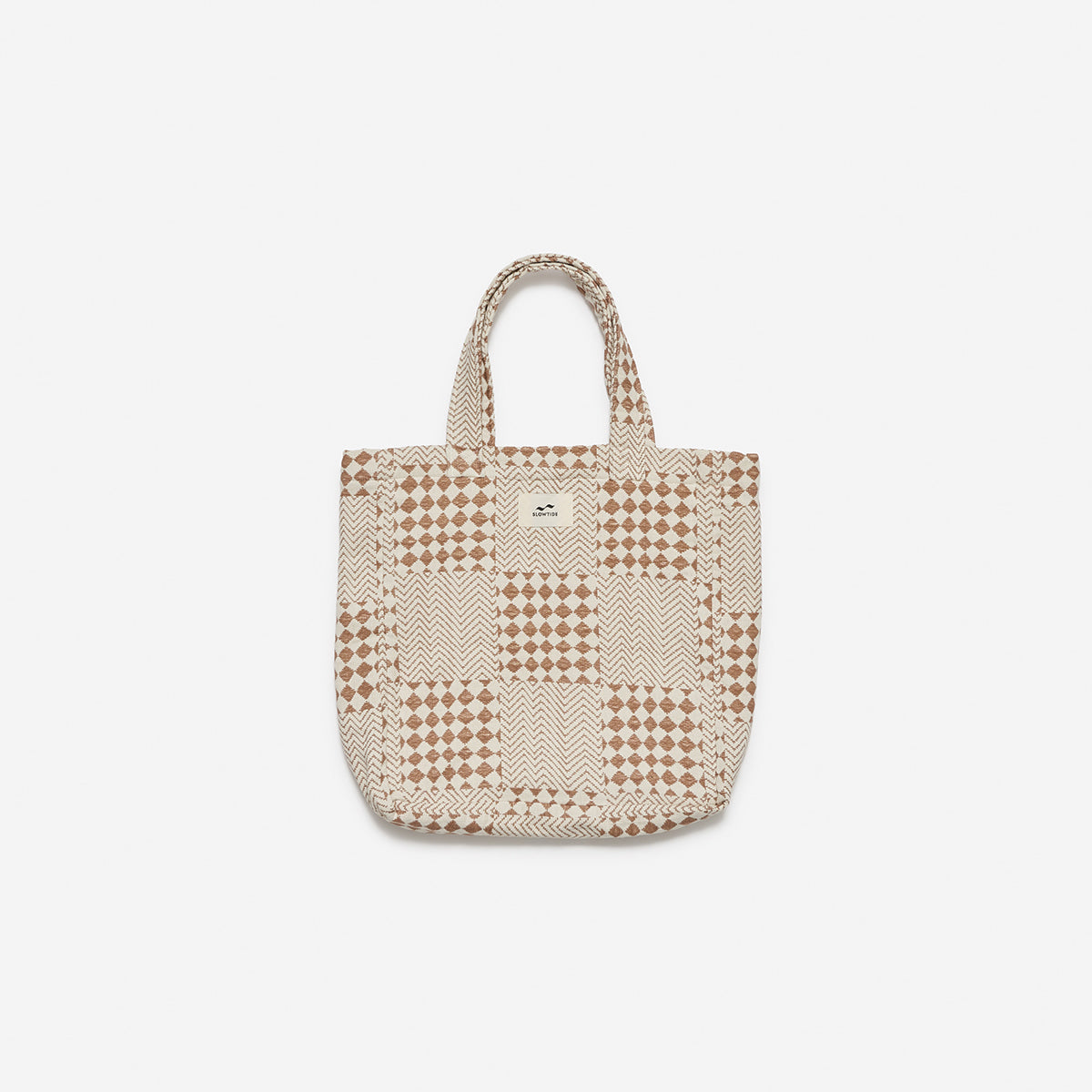 Tote bag in cotton canvas with a beige and brown geometric patchwork pattern.
