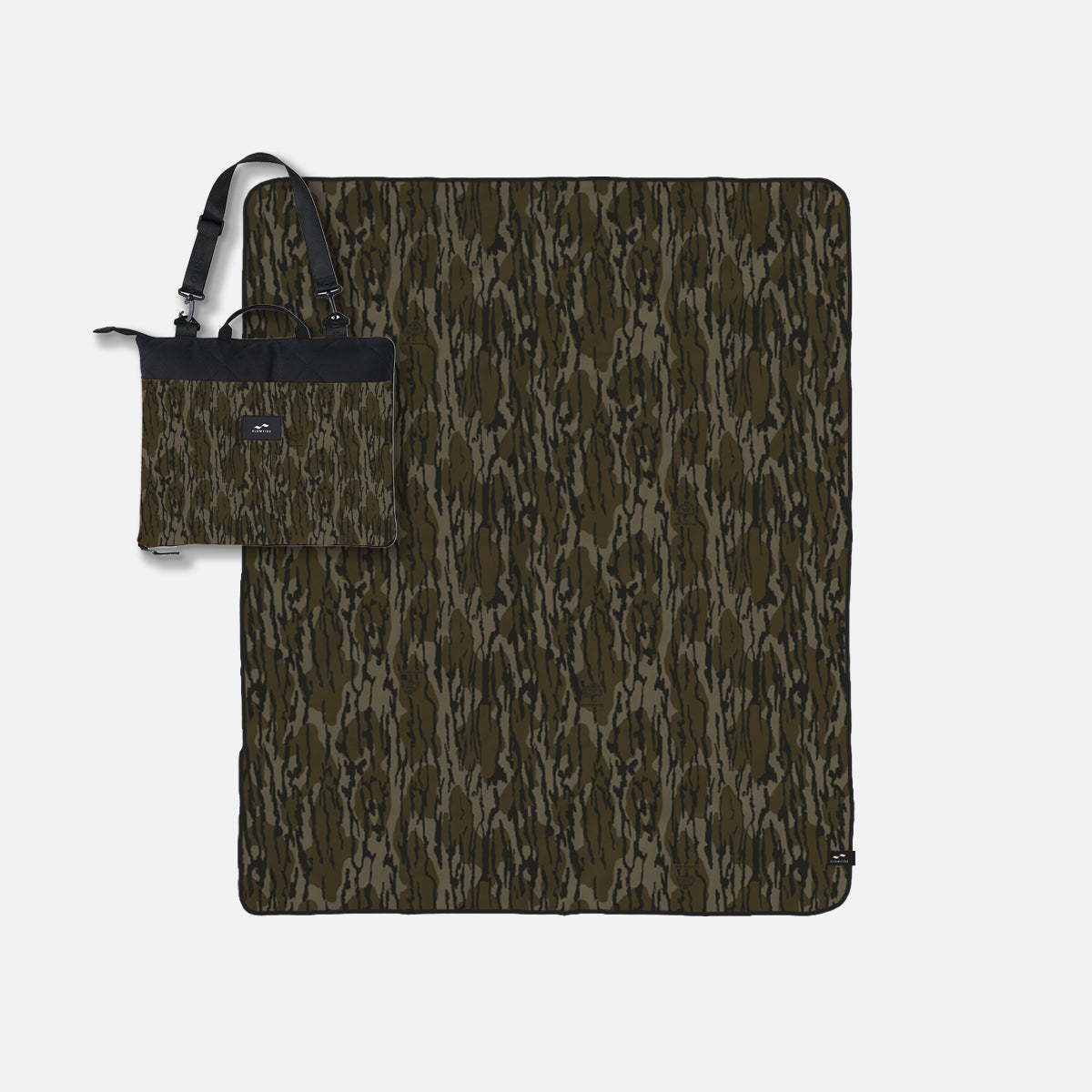 Outdoor blanket in camouflage pattern with black handle, shown folded and unfolded.