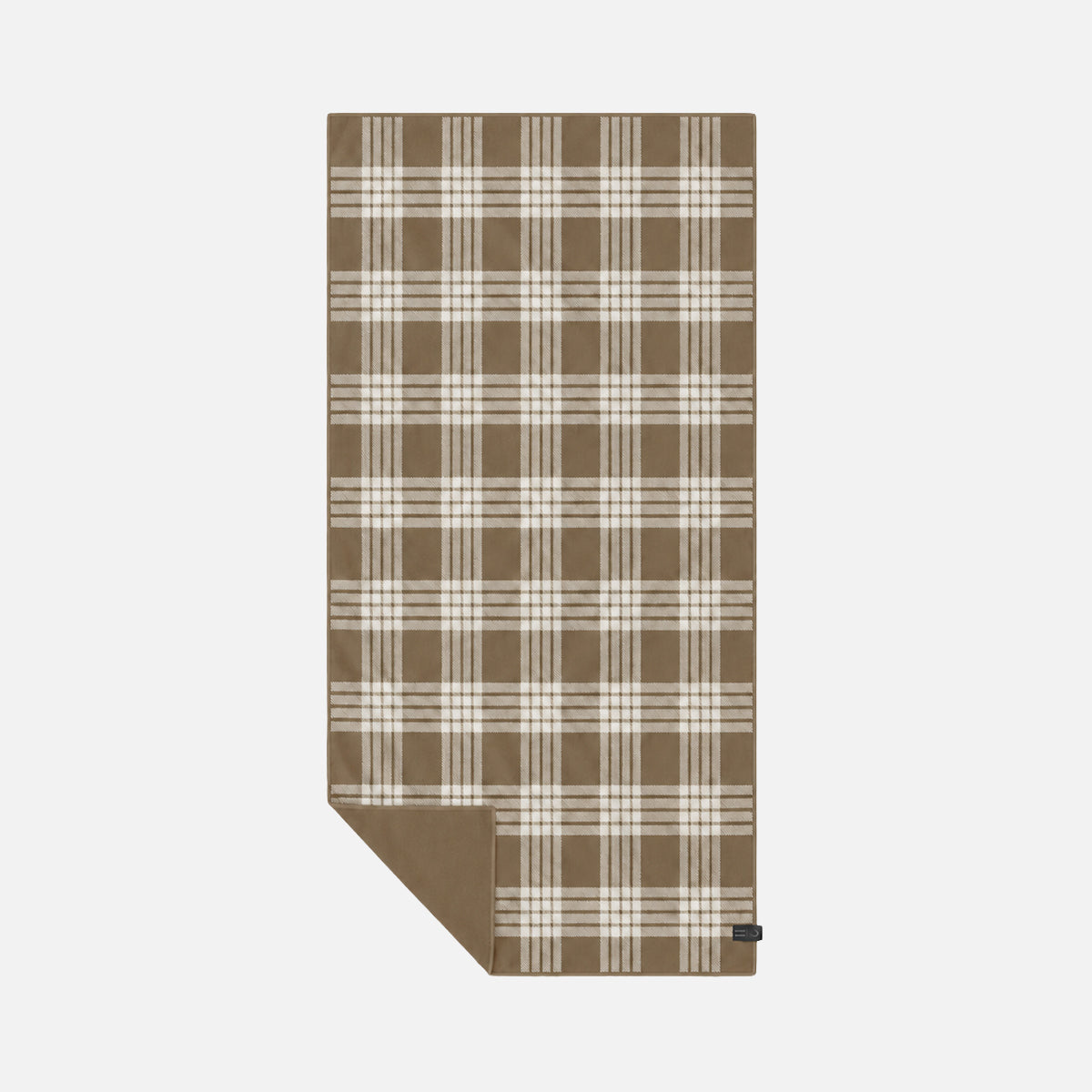 Plaid brown and white sustainable towel with folded corner on plain background.