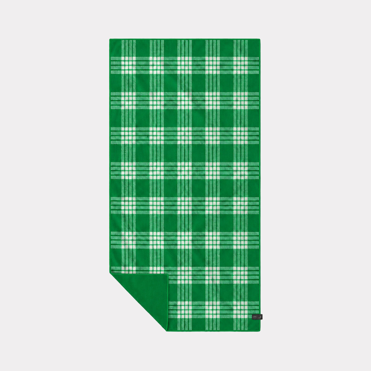 Plaid green and white sustainable towel with folded corner showing solid green underside.