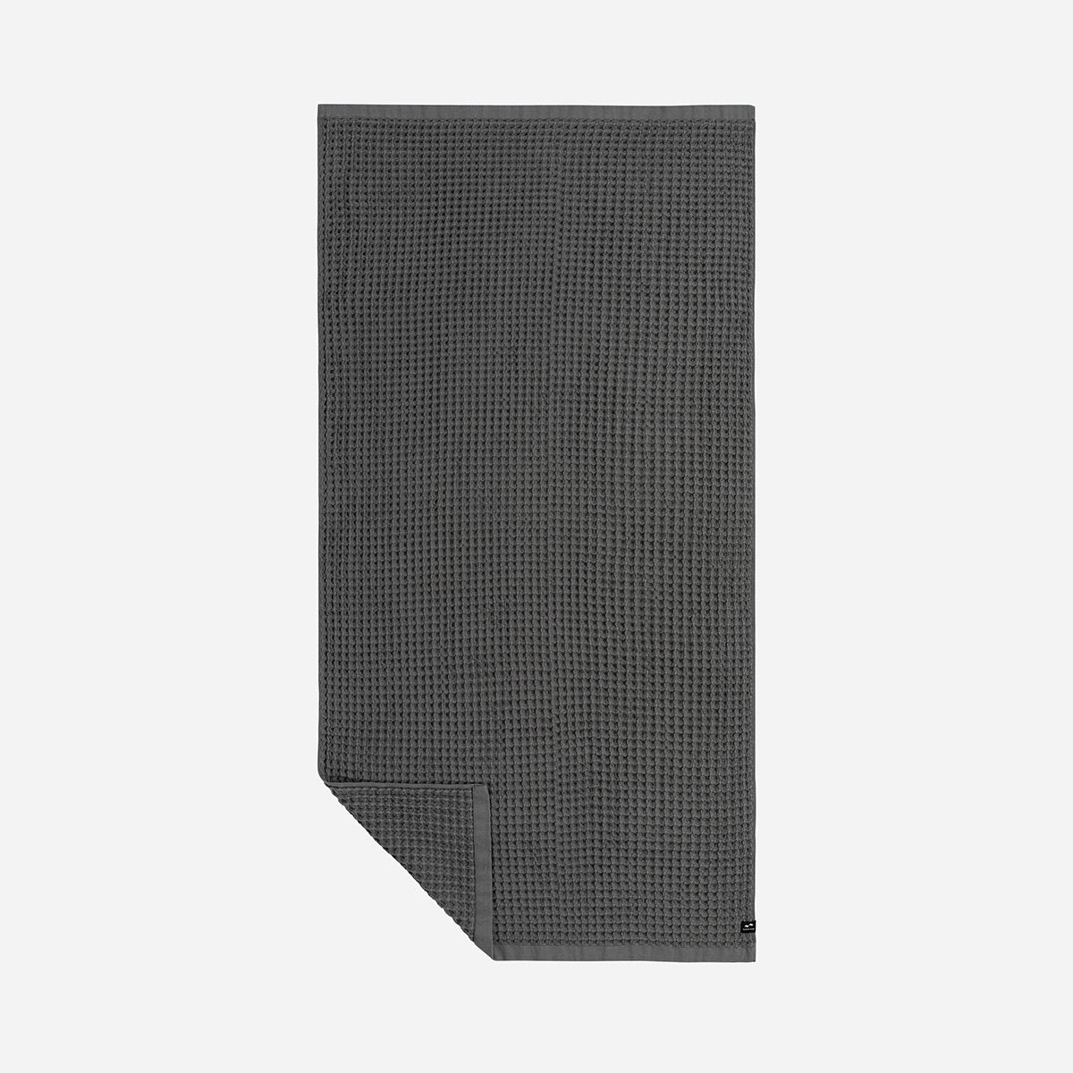 Waffle bath towel, dark gray, neatly folded on a plain light background.