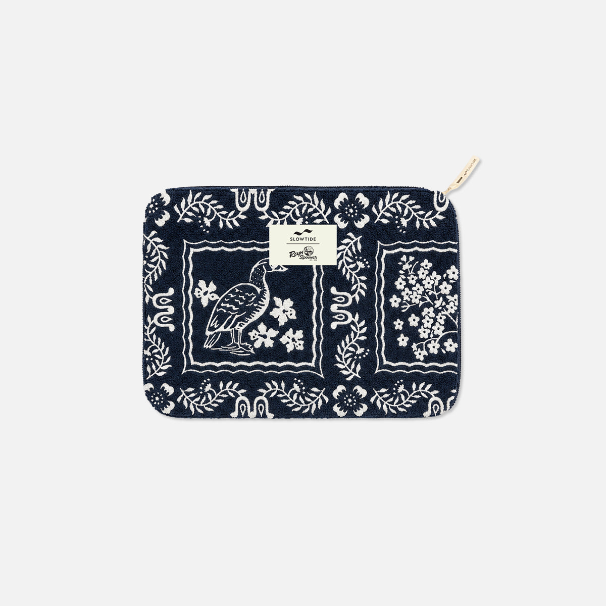 Navy terry pouch with white floral and bird print, gold zipper, and centered small label.