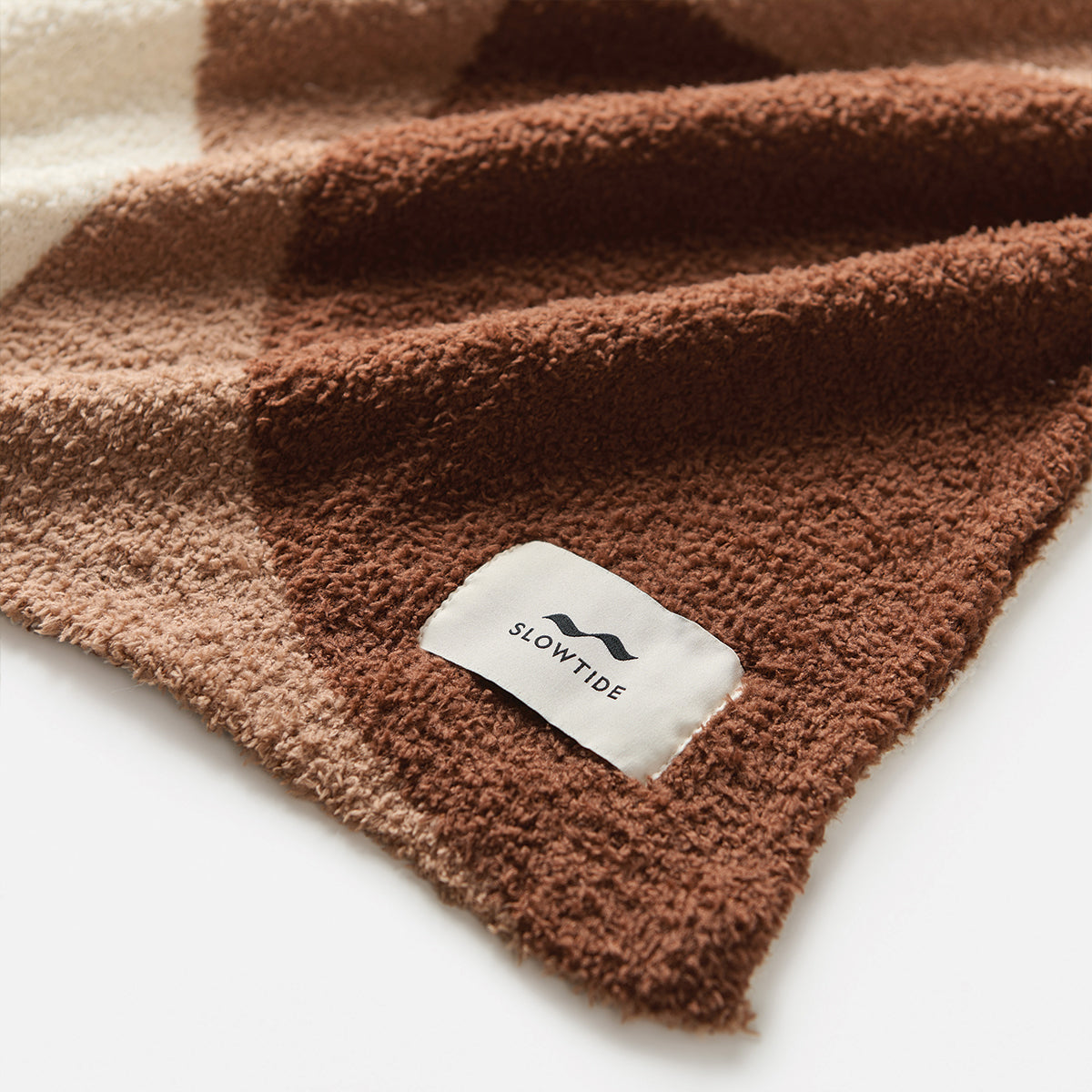 Plush blanket in fuzzy brown and cream color-blocked design.