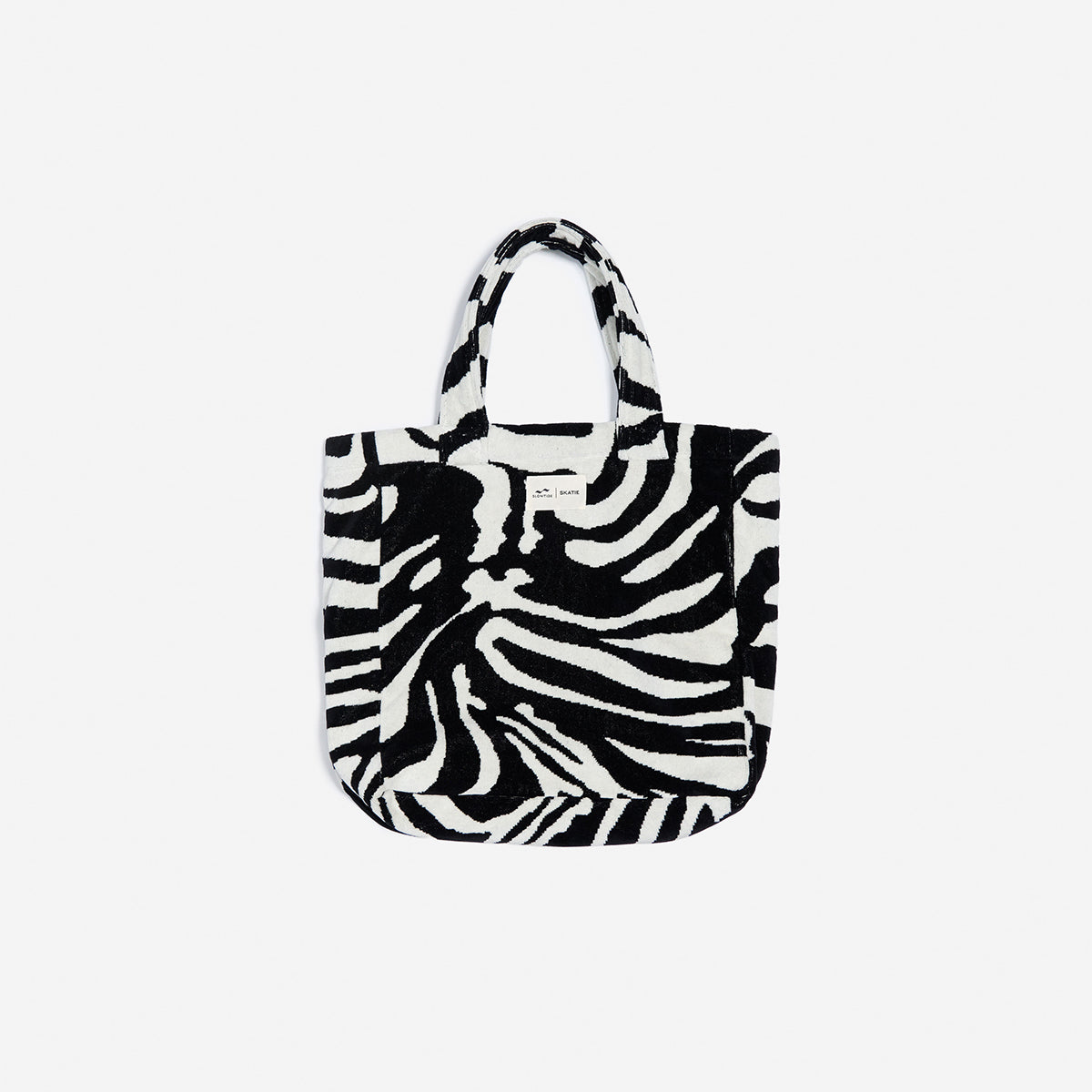 Tote bag, cotton canvas with zebra print and handles, plain background.