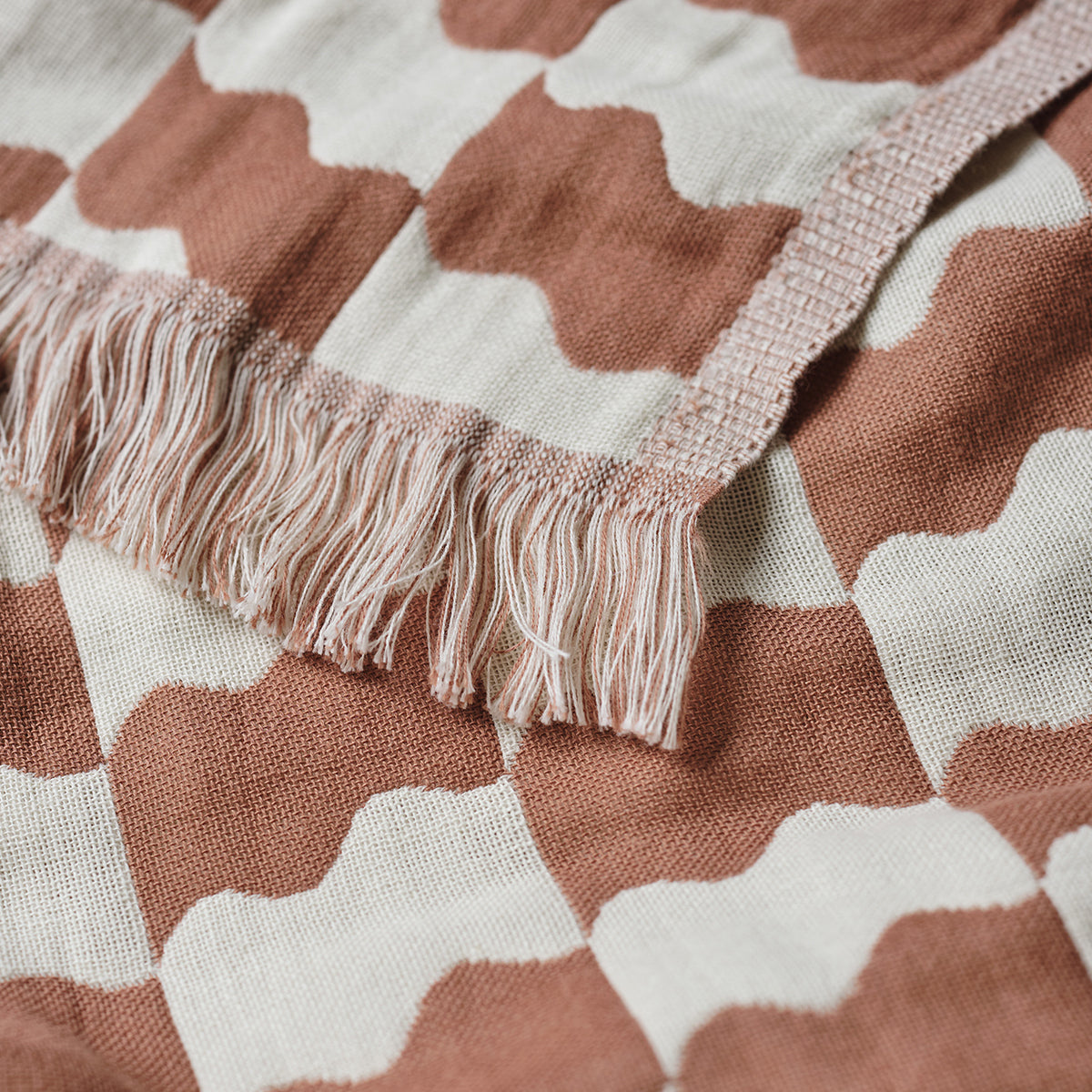 Turkish towel, lightweight cotton with wavy brown and white pattern and fringed edge.