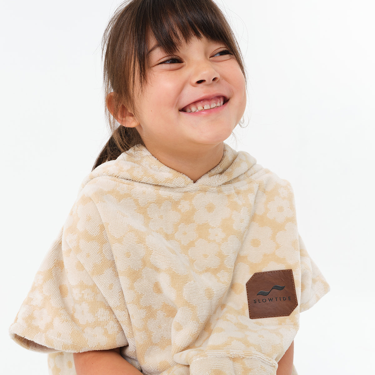 Kids poncho in beige floral cotton terry with logo patch.