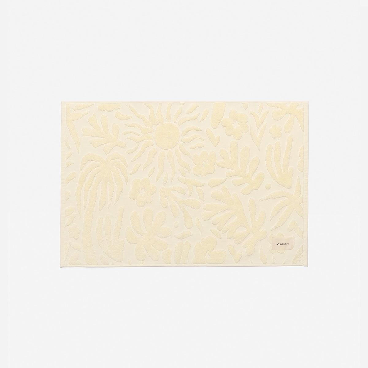 Bath mat, cream color with raised floral pattern, spa-inspired design.