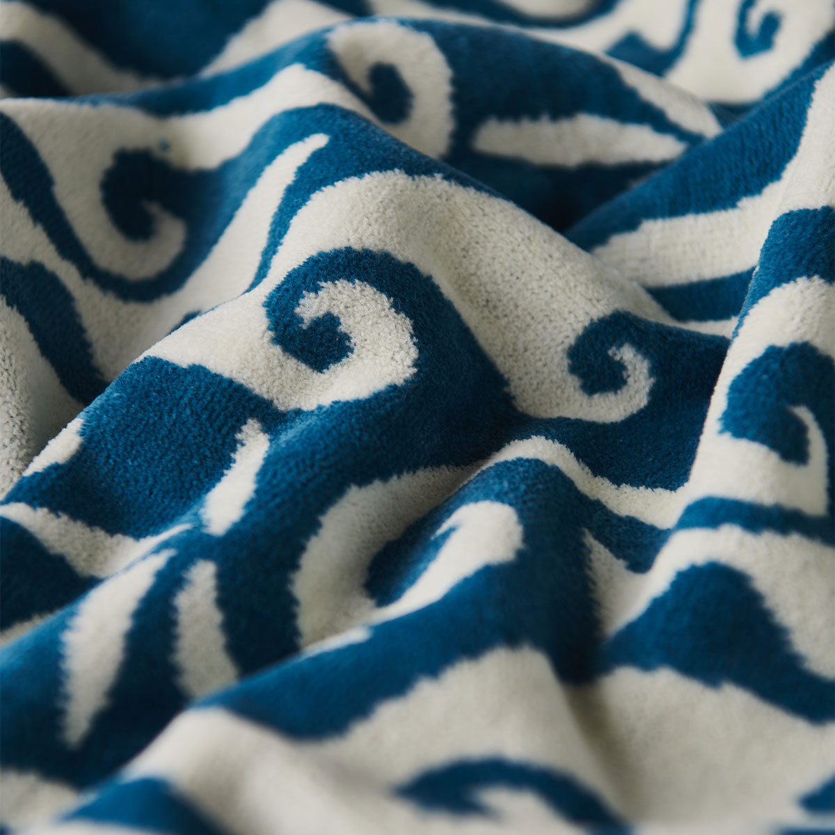 Towel with soft fabric and blue and white wave pattern, close-up view.