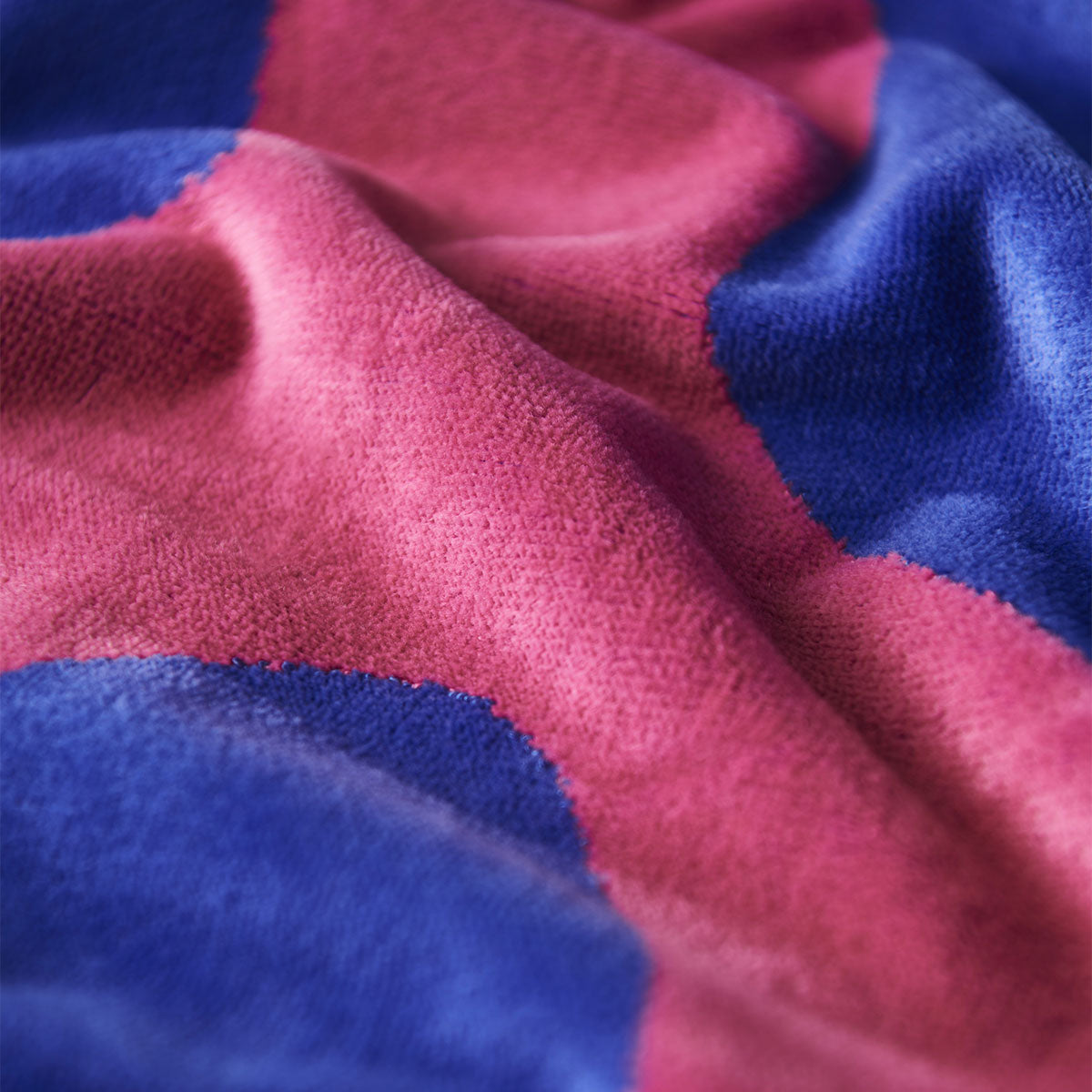 Woven towel with soft pink and blue checkerboard pattern, close-up view.