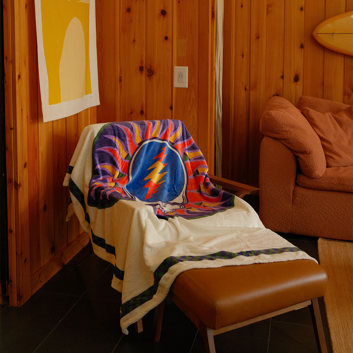 Oversized throw blanket with sun and lightning bolt design draped on chair.