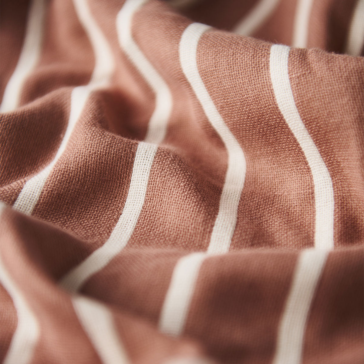 Oversized terracotta towel with white vertical stripes.