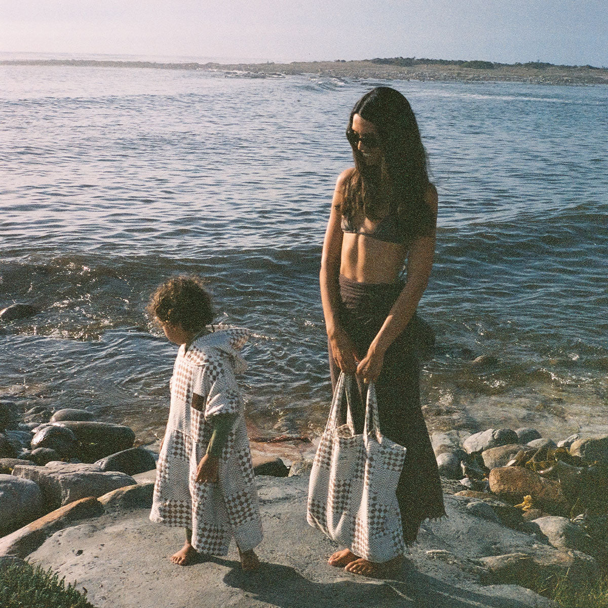 Absorbent cotton swim poncho and matching tote bag in a cream and brown checkered print.