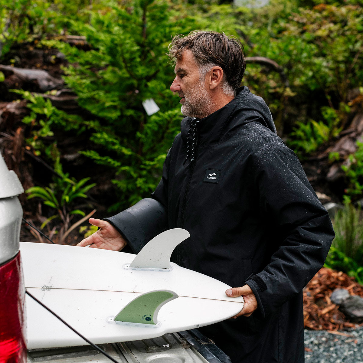 Black insulated jacket with surfboard featuring green fins.