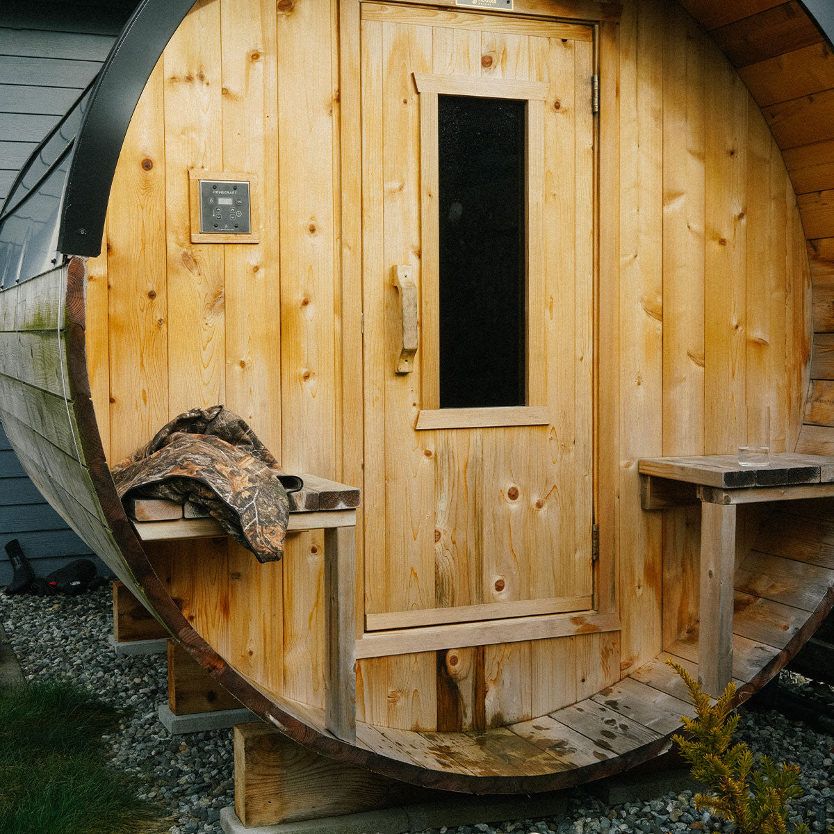 Wooden sauna with benches, quick dry woodland camo towel on left bench.