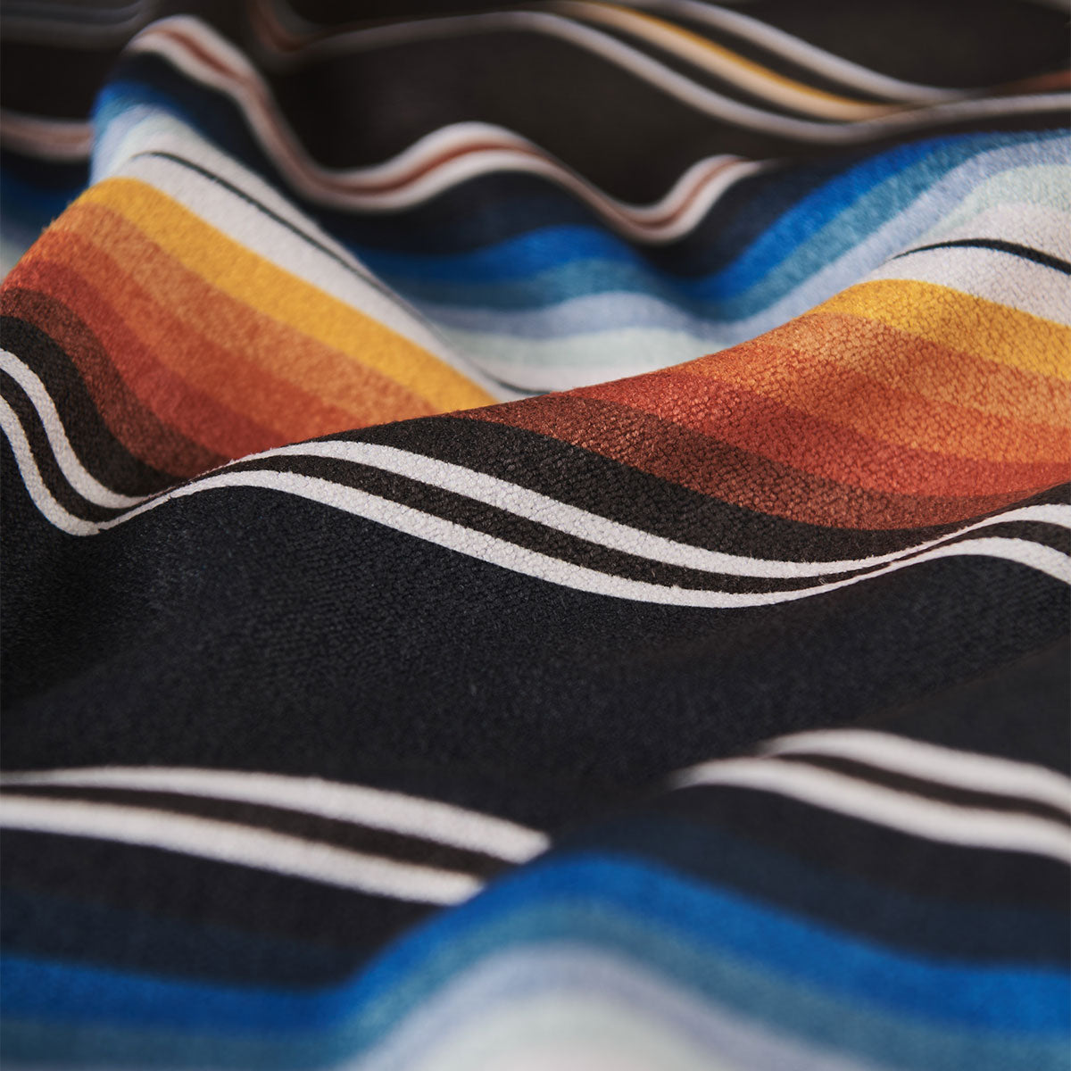 Quick-dry towel made from recycled bottles with multicolor stripes, close-up view.