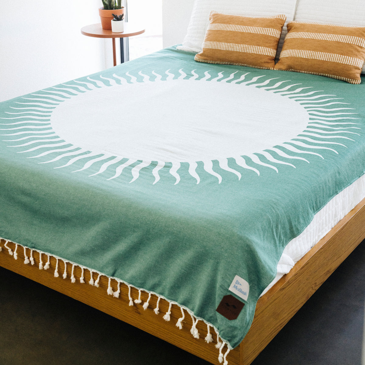 Cotton blanket with white sunburst pattern on bed.