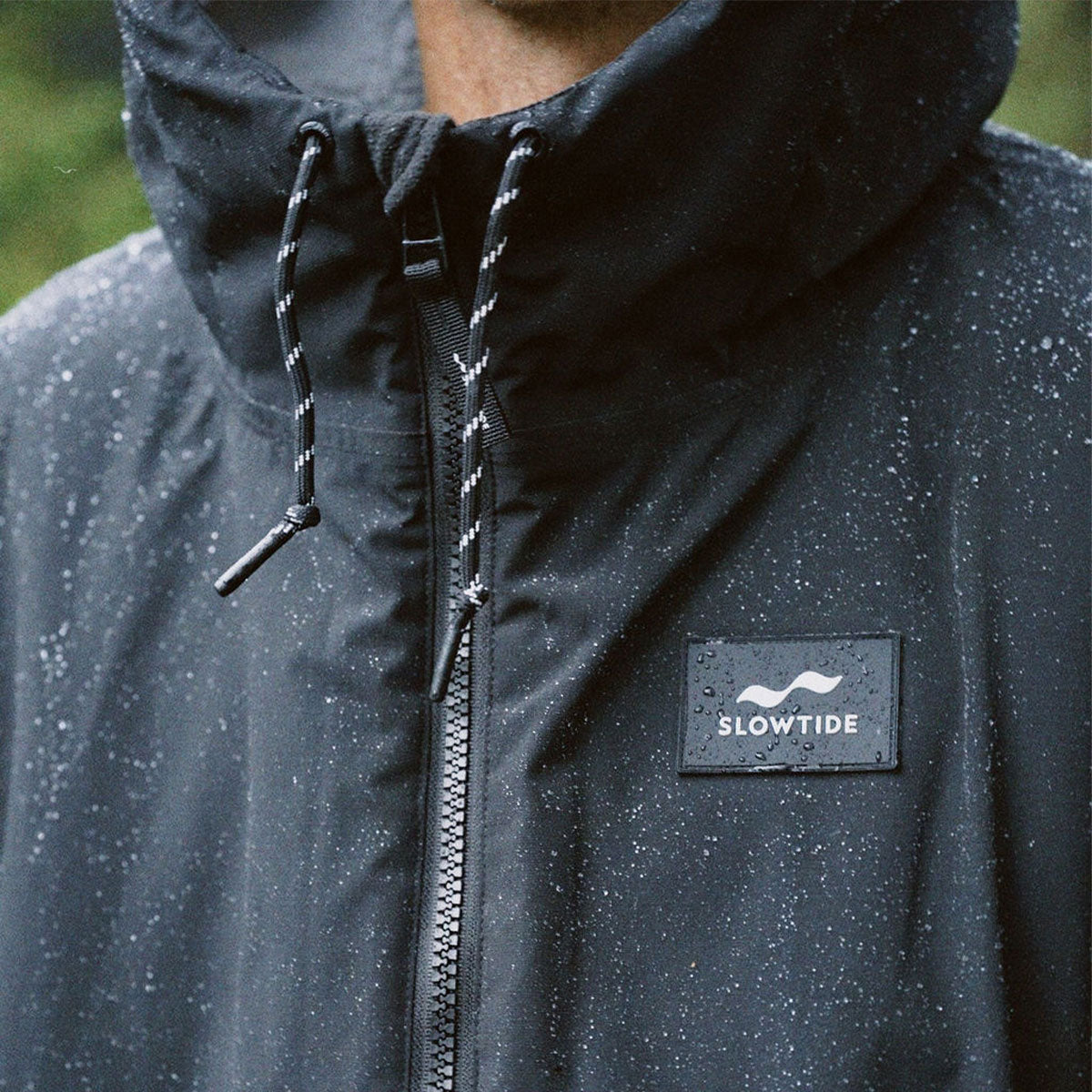 Black all-weather parka with water-repellent fabric shown in close-up.