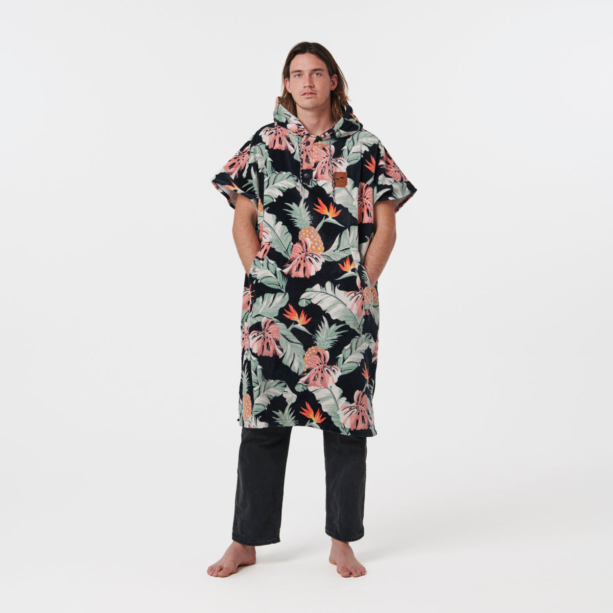 Absorbent poncho with floral pattern over black pants.