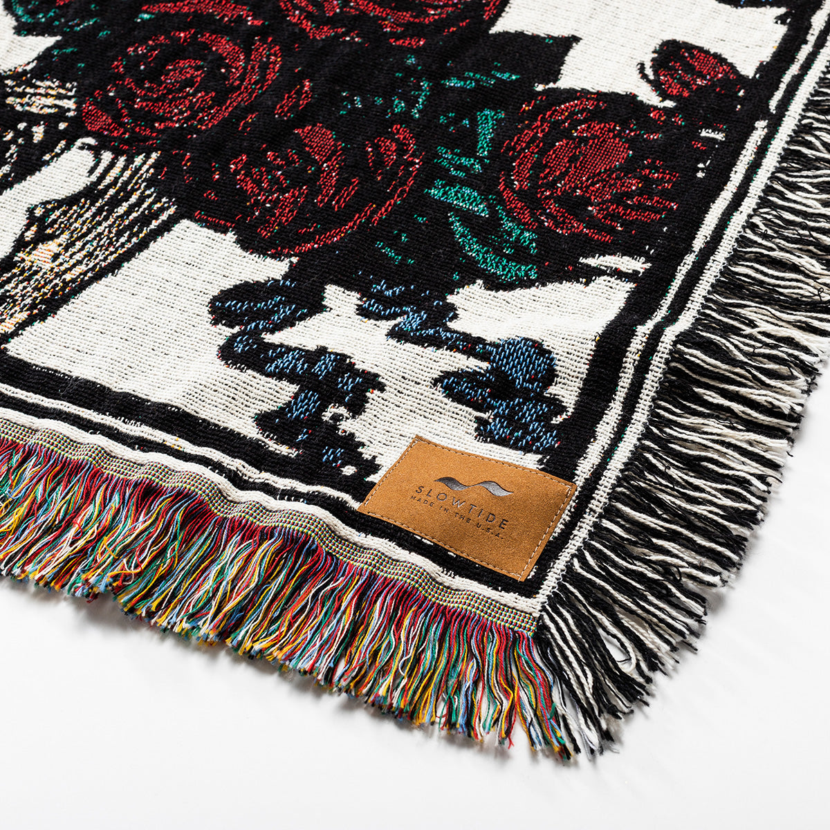 Oversized woven blanket with multicolored fringe and unique pattern.