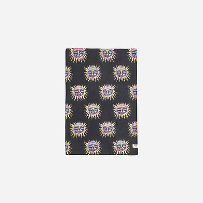 Black absorbent towel with yellow, purple, and orange sun print pattern.