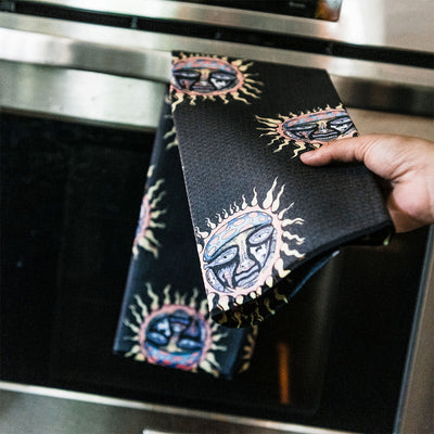 Black sun print folder with colorful designs, displayed in a kitchen setting.