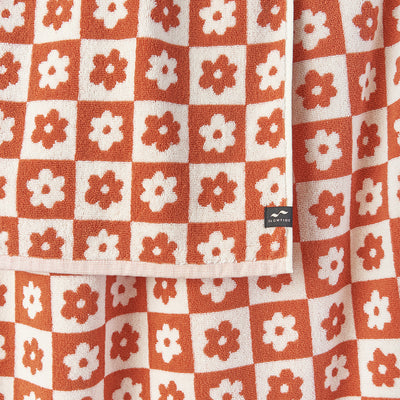 Bath towel, 100 cotton, orange and white floral geometric checkerboard pattern.