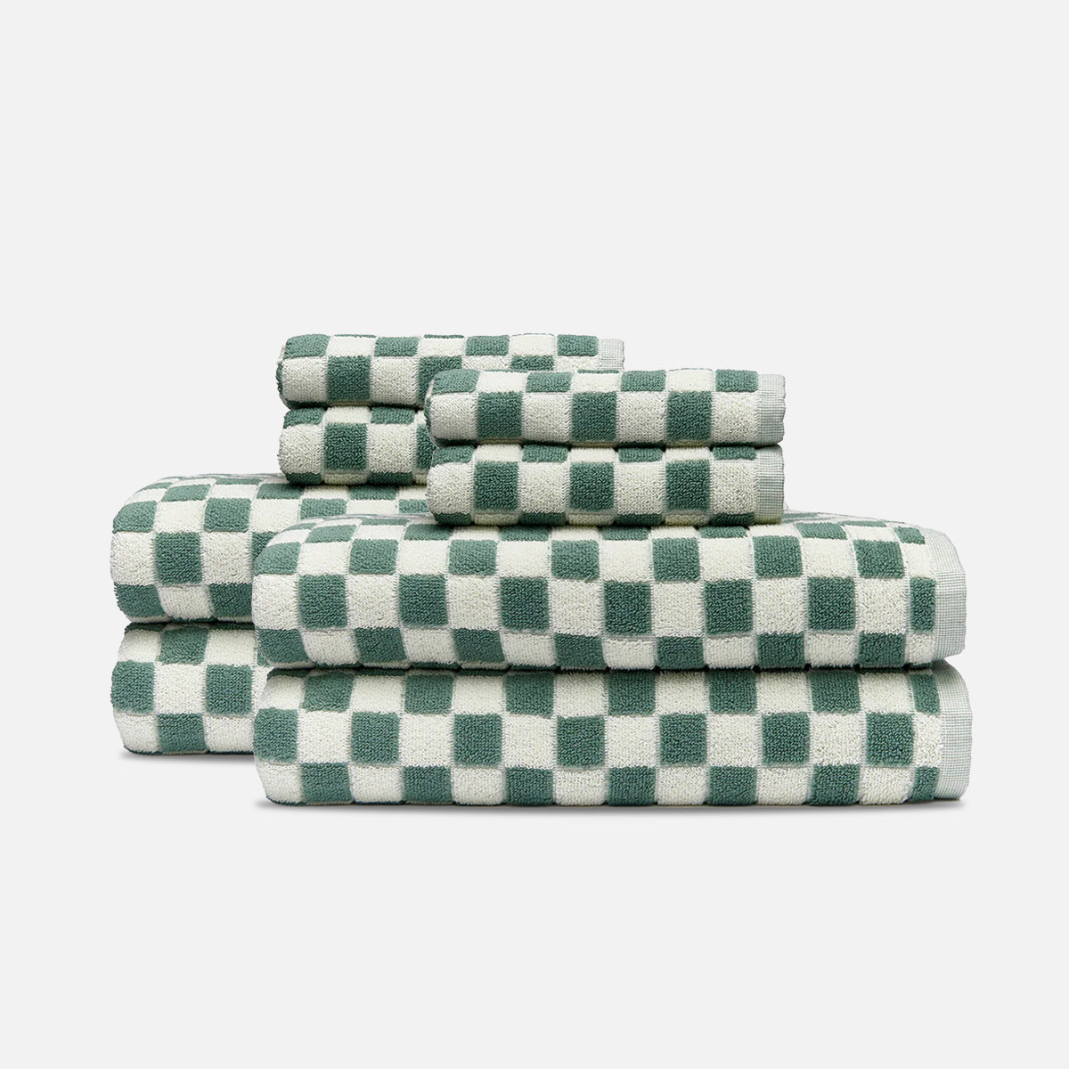 Bath towels, absorbent cotton, sage green and white checkered pattern, stacked in three piles.