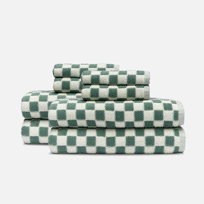 Bath towels, absorbent cotton, sage green and white checkered pattern, stacked in three piles.