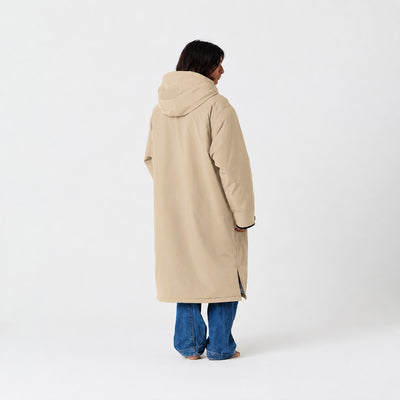 Beige waterproof parka with blue jeans, rear view.
