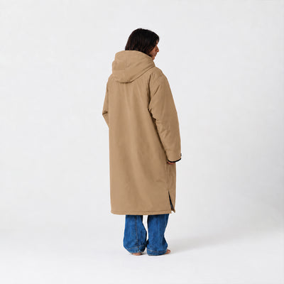 Tan all-weather parka with hood, paired with blue jeans, shown from the back.